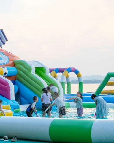 Children playing on a colorful inflatable water park