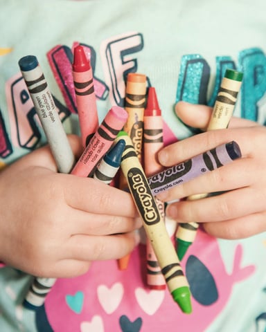 Child holding colorful Crayola crayons