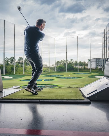 Golfer at a Topgolf driving range bay