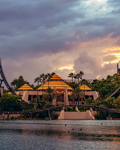Universal Orlando Resort at sunset with roller coasters and castle