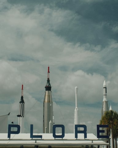 Rockets on display at Kennedy Space Center with Explore sign