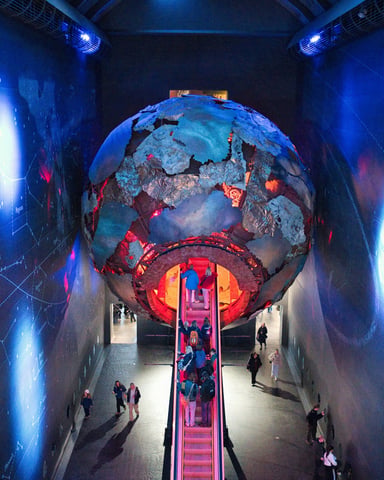 Dramatic science museum interior with glowing globe installation